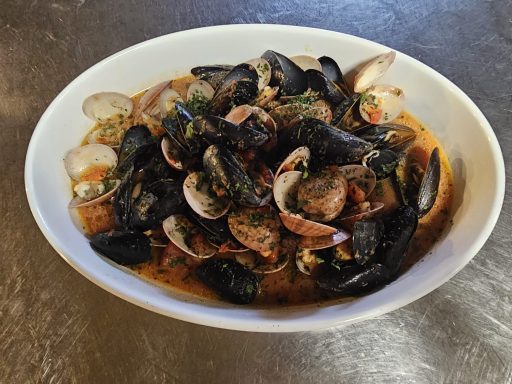 Eine Schüssel mit Muscheln und Schellyfischen in einer würzigen Tomatensauce.